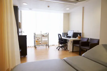 GP consulting room with desk and examination couch